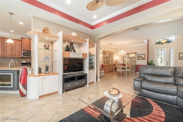 living room featuring crown molding, light tile patterned floors, and ceiling fan with notable chandelier