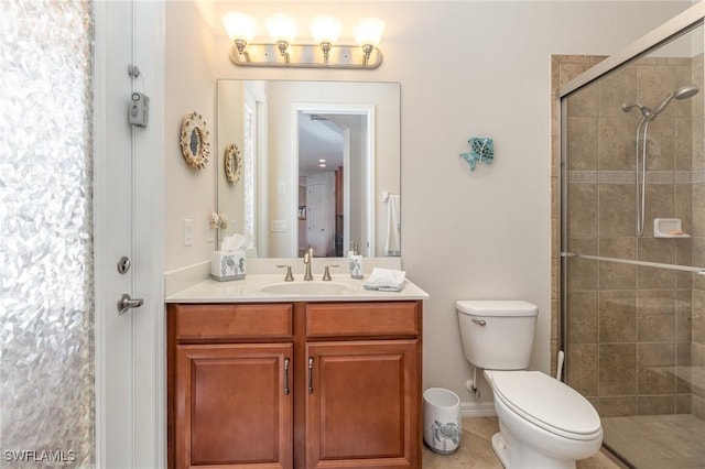 bathroom with toilet, vanity, tile patterned floors, and tiled shower