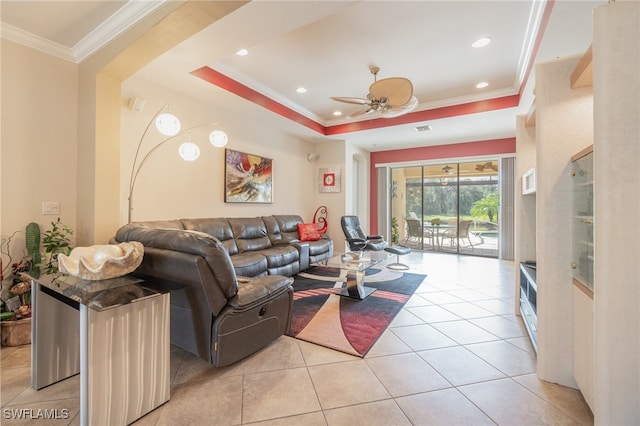 tiled living room featuring crown molding, a raised ceiling, and ceiling fan