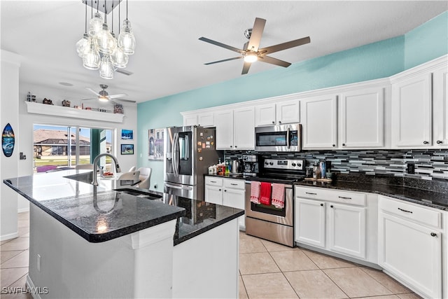 kitchen with white cabinets, stainless steel appliances, and a center island with sink