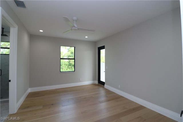 empty room with ceiling fan and light hardwood / wood-style floors