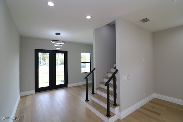 foyer with french doors and light hardwood / wood-style floors