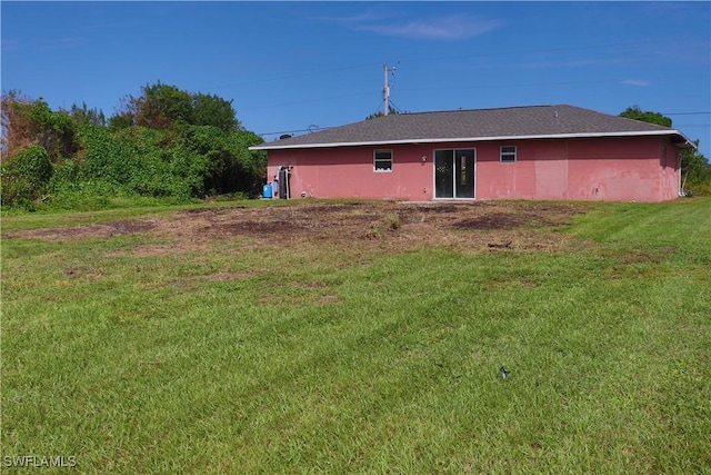 rear view of house featuring a lawn