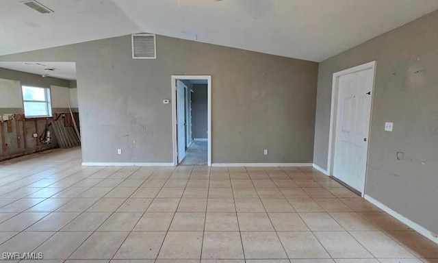 unfurnished room featuring light tile patterned flooring and vaulted ceiling