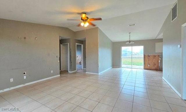 tiled spare room featuring vaulted ceiling and ceiling fan with notable chandelier