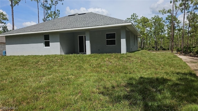 back of house featuring a lawn