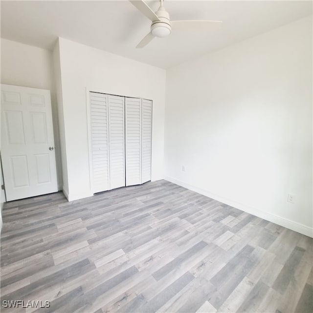 unfurnished bedroom featuring light hardwood / wood-style flooring, a closet, and ceiling fan