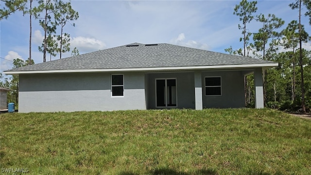 rear view of house featuring a yard