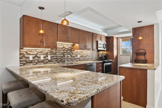 kitchen with sink, hanging light fixtures, kitchen peninsula, stainless steel appliances, and backsplash