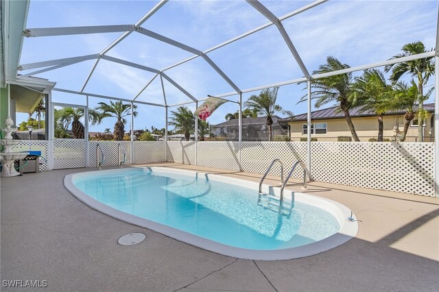 view of pool with a patio and glass enclosure