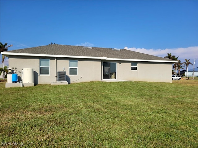 rear view of house featuring a yard and central air condition unit