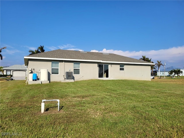 rear view of property featuring a lawn and cooling unit