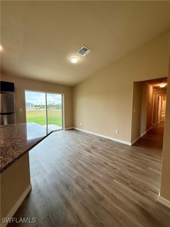 unfurnished living room with hardwood / wood-style flooring and lofted ceiling