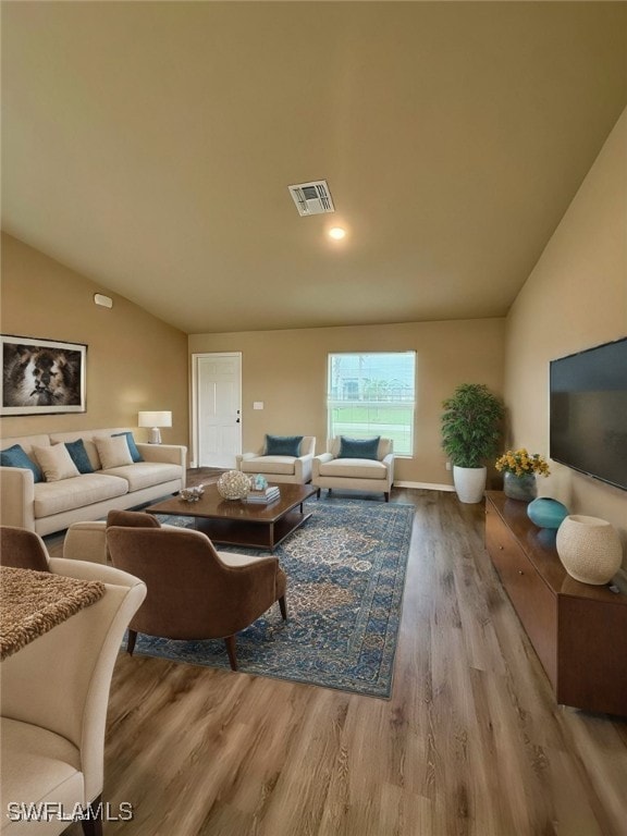 living room with light hardwood / wood-style flooring and lofted ceiling