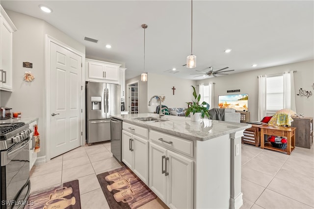 kitchen featuring an island with sink, white cabinetry, sink, pendant lighting, and stainless steel appliances