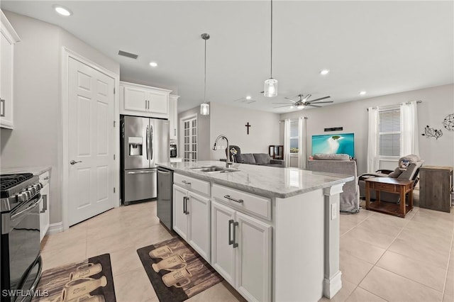 kitchen with visible vents, light stone countertops, appliances with stainless steel finishes, light tile patterned flooring, and a sink