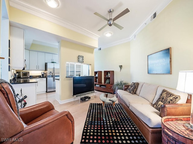 living room with ceiling fan, crown molding, and light hardwood / wood-style floors