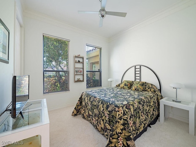 carpeted bedroom with ornamental molding and ceiling fan