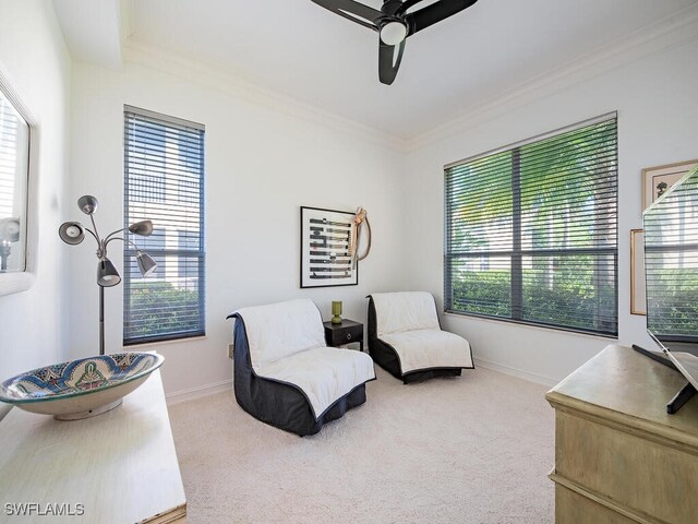 sitting room featuring crown molding, carpet flooring, a healthy amount of sunlight, and ceiling fan