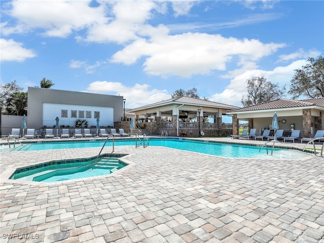 view of pool featuring a community hot tub and a patio