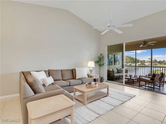 tiled living room with a water view, ceiling fan, and high vaulted ceiling