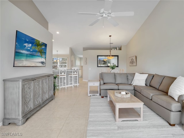 tiled living room with lofted ceiling and ceiling fan with notable chandelier