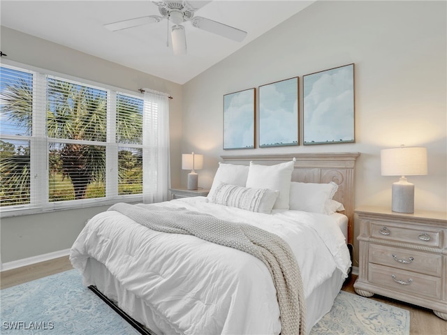 bedroom featuring light hardwood / wood-style flooring, ceiling fan, and vaulted ceiling