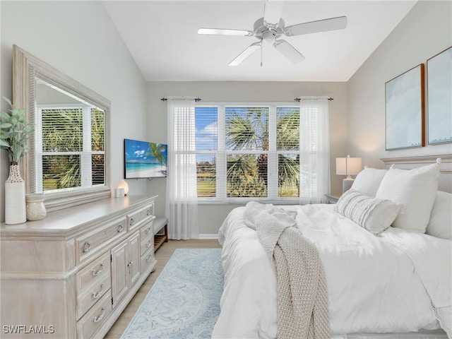 bedroom with light hardwood / wood-style flooring, ceiling fan, and lofted ceiling