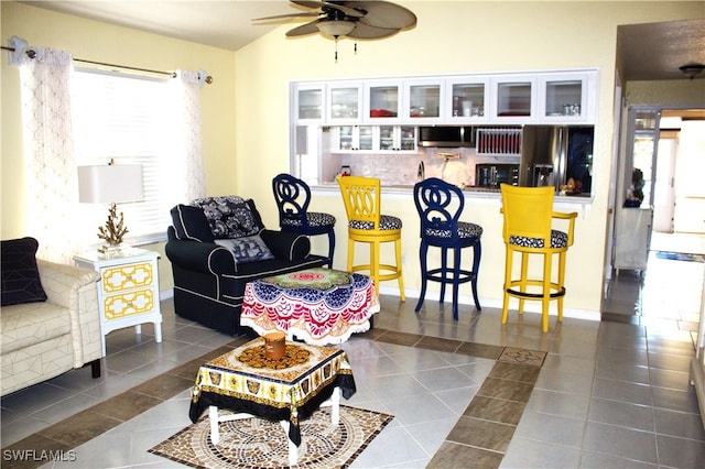 tiled living room featuring ceiling fan and lofted ceiling