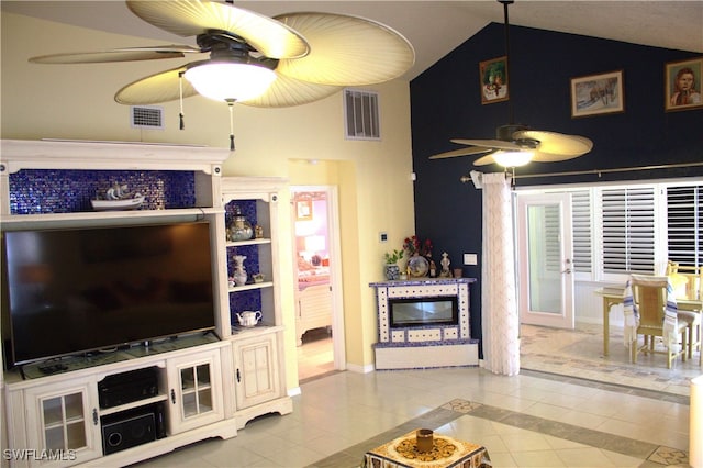 living room with lofted ceiling, ceiling fan, and light tile patterned floors