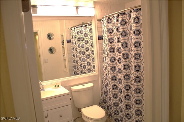 bathroom with toilet, curtained shower, and vanity