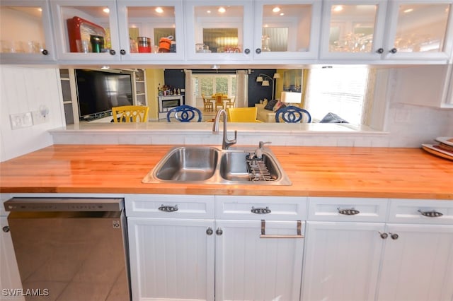 kitchen featuring wood counters, dishwasher, sink, and white cabinets