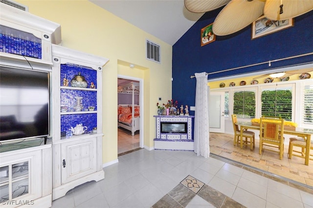 tiled living room featuring high vaulted ceiling