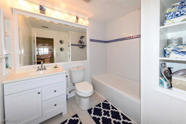 full bathroom with tile patterned floors, toilet, tiled shower / bath combo, and vanity