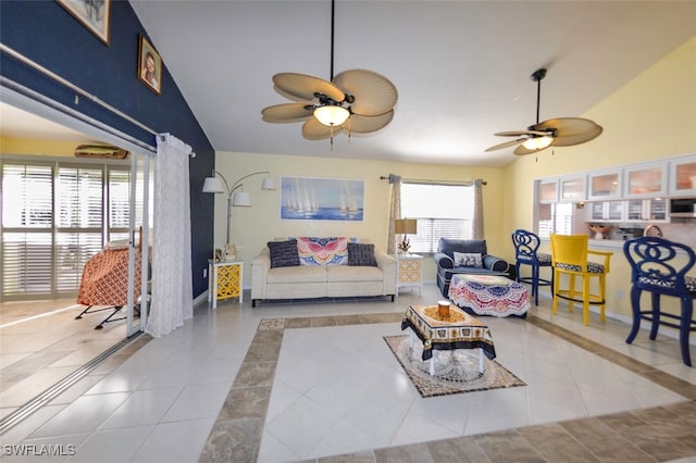 living room featuring light tile patterned flooring, vaulted ceiling, and ceiling fan