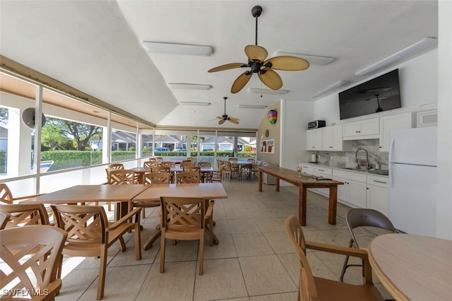 tiled dining space featuring lofted ceiling and sink