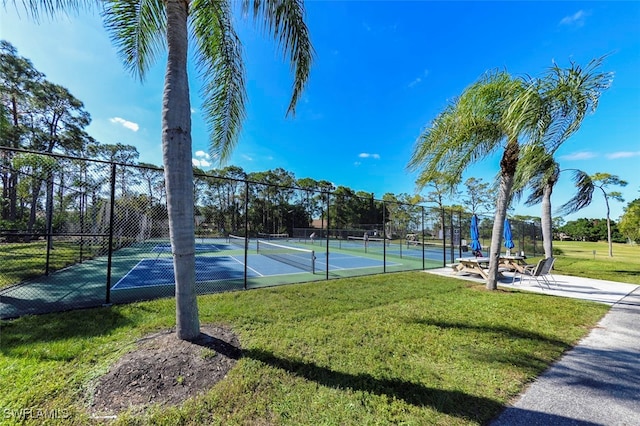 view of tennis court with a yard