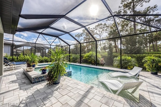 view of pool with a patio area, a hot tub, and glass enclosure