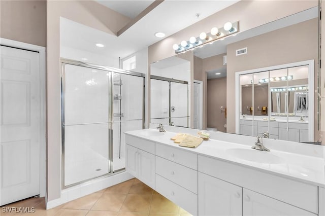 bathroom featuring tile patterned floors, vanity, toilet, and walk in shower