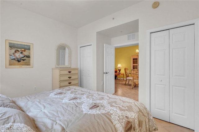 bedroom featuring two closets and light tile patterned flooring