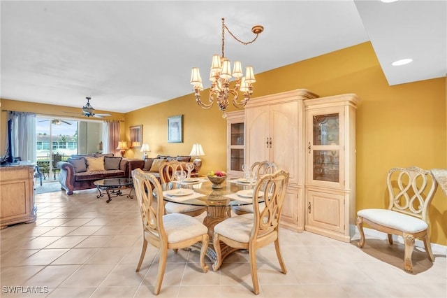 tiled dining room featuring ceiling fan with notable chandelier