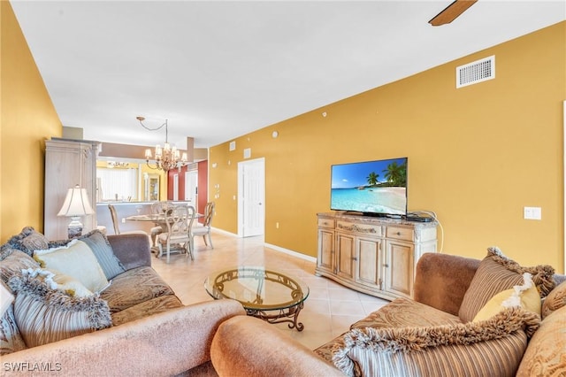 tiled living room featuring ceiling fan with notable chandelier