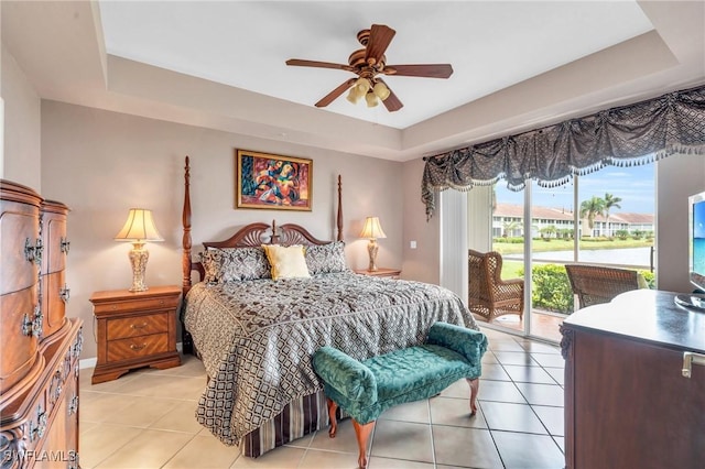 bedroom with light tile patterned floors, access to outside, a raised ceiling, and ceiling fan