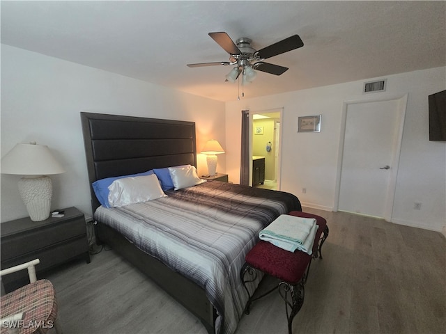 bedroom with wood-type flooring, connected bathroom, and ceiling fan