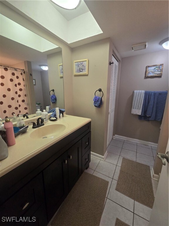 bathroom featuring tile patterned flooring, a shower with shower curtain, and vanity