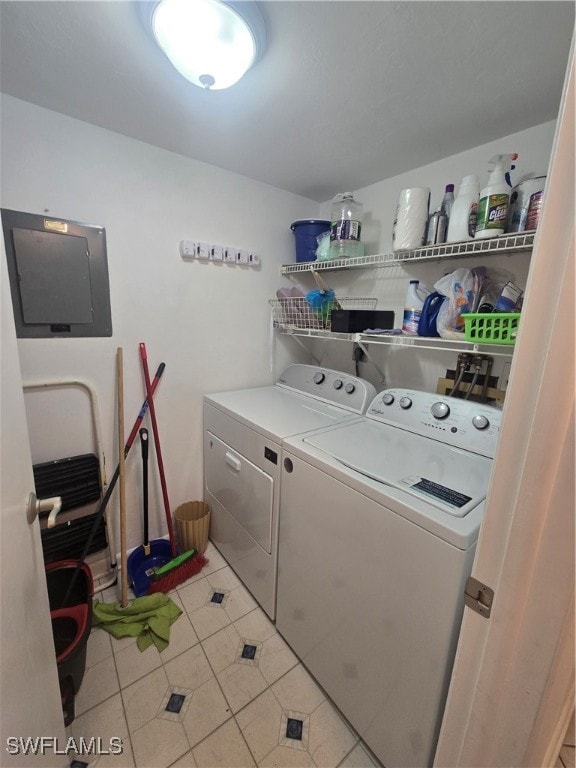 laundry area featuring washer and clothes dryer, electric panel, and light tile patterned flooring