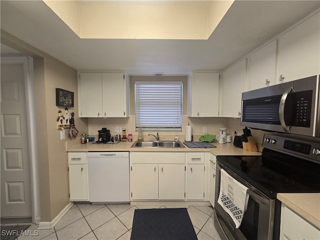 kitchen featuring tasteful backsplash, white cabinets, sink, appliances with stainless steel finishes, and light tile patterned floors