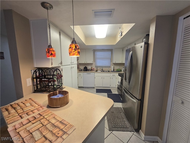 kitchen featuring light tile patterned flooring, white dishwasher, stainless steel fridge, sink, and white cabinetry