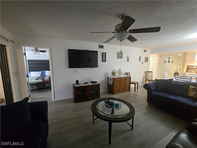 living room with ceiling fan, hardwood / wood-style floors, and a textured ceiling