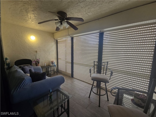 interior space with ceiling fan, hardwood / wood-style floors, and a textured ceiling